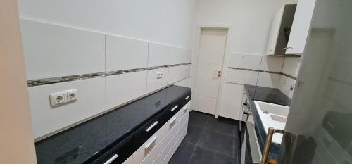 a kitchen with white cabinets and a sink at RS Zimmervermietung in Euskirchen