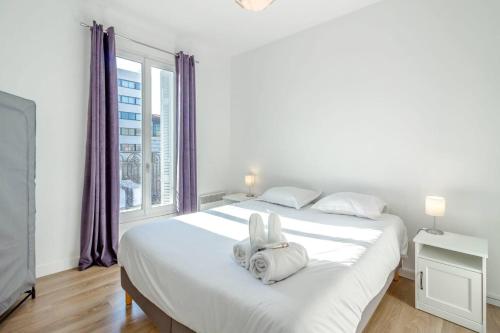 um quarto com uma grande cama branca com cortinas roxas em Canebière 3 // Bel appartement climatisé avec terrasse em Marselha