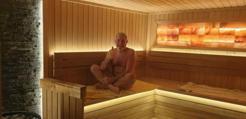 a man is sitting in a sauna at Modern Top Floor Sea View 3BR with Pools, Spa & Fitness in Becici