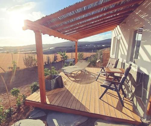 a wooden deck with a table and chairs on it at La Pérgola Calma in San Bartolomé de Tirajana