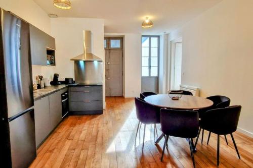 une cuisine avec une table et des chaises dans une pièce dans l'établissement La Parqueterie - 2 pas des thermes - 6 voyageurs, à Bagnères-de-Bigorre