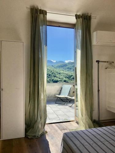 a bedroom with a door open to a patio with a chair at m.a.r.e. in Calice Ligure