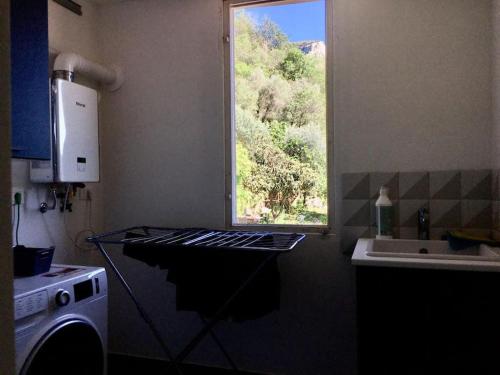 uma cozinha com uma janela, um fogão e um lavatório em m.a.r.e. em Calice Ligure
