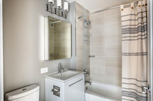 La salle de bains est pourvue d'un lavabo, de toilettes et d'une douche. dans l'établissement UES 1BR w Gym WD nr Central Park NYC-1296, à New York