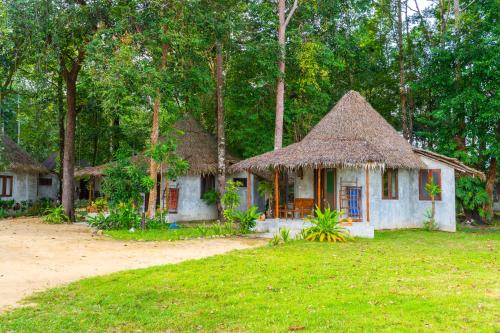a small house with a thatched roof in a yard at The Tropical Beach Resort in Ko Chang