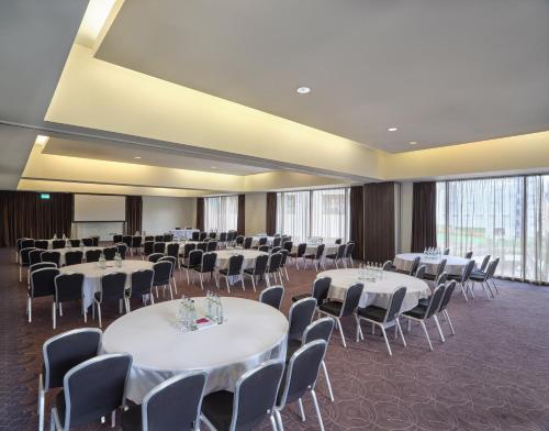 a banquet hall with white tables and chairs at Crowne Plaza Birmingham City by IHG in Birmingham