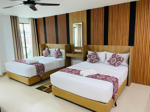 a bedroom with two beds and a window at Cozy Hotel@ KL Sentral in Kuala Lumpur
