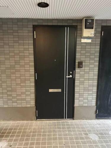 a black door in a building with a tile floor at ラフォレ１０１　新宿から13分のくつろげるお部屋 in Tokyo