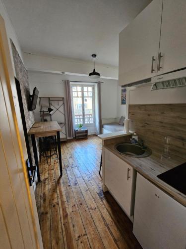 Il comprend une cuisine avec un évier et du parquet. dans l'établissement Le Henri IV - hyper centre - quartier du château, à Pau