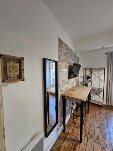 Cette chambre dispose d'une table en bois et d'une fenêtre. dans l'établissement Le Henri IV - hyper centre - quartier du château, à Pau