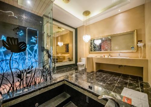 a bathroom with a tub and a sink and a shower at Feng Cai Motel in Yuanlin