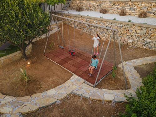 a woman and a child playing on a swing at Chariclea Villas Retreat in Samos
