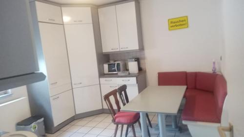 a kitchen with a table and two chairs and a microwave at Da lillo in Fuldatal