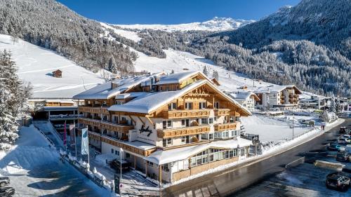 a ski lodge in the mountains with snow at Hotel Andy 4 Sterne Superior in Jerzens