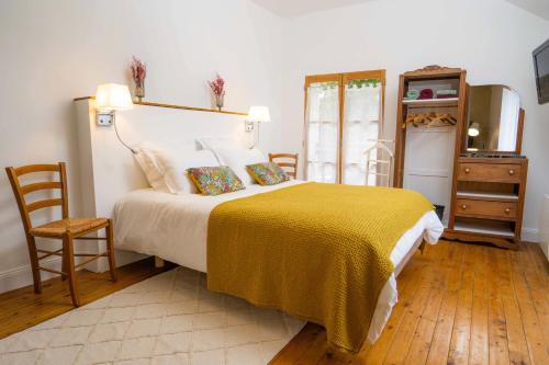 Les Balcons sur la Loire في Chalonnes-sur-Loire: غرفة نوم بسرير كبير مع بطانية صفراء