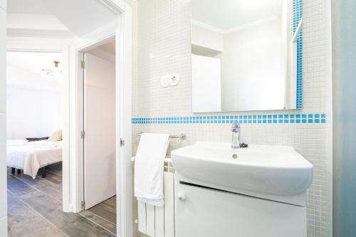 a white bathroom with a sink and a mirror at VENTURA Y LA BARAGAÑA (Vivienda turística en Candás) in Candás