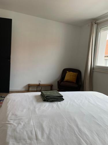 a bedroom with a bed and a chair and a window at Chambre Cavaignac in Calais