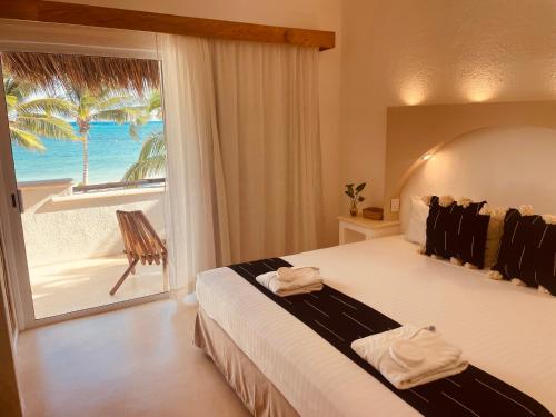 a bedroom with a bed with a view of the ocean at VR CLUB Tulum Riviera in Tulum