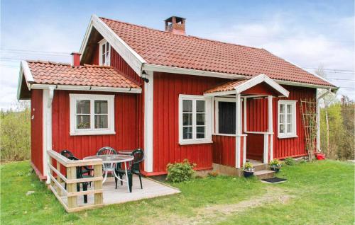 a red house with a table in front of it at Lovely Home In Härryda With Kitchen in Hindås