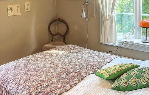 un letto con due cuscini e una finestra di Lovely Home In Hrryda With Kitchen a Hindås