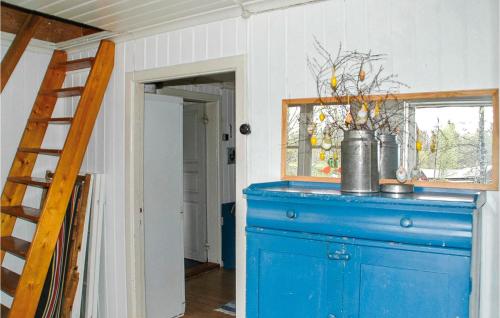 Lovely Home In Hrryda With Kitchen في Hindås: خزانة ملابس زرقاء في غرفة بها سلم