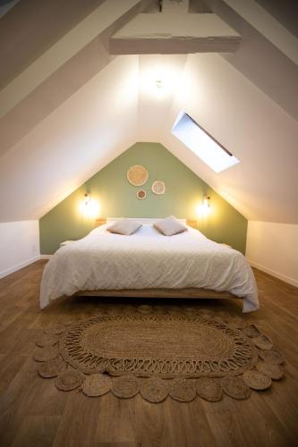 une chambre avec un grand lit dans un grenier dans l'établissement Appartement Duplex en Centre-Ville de Cambrai - 110m2, à Cambrai