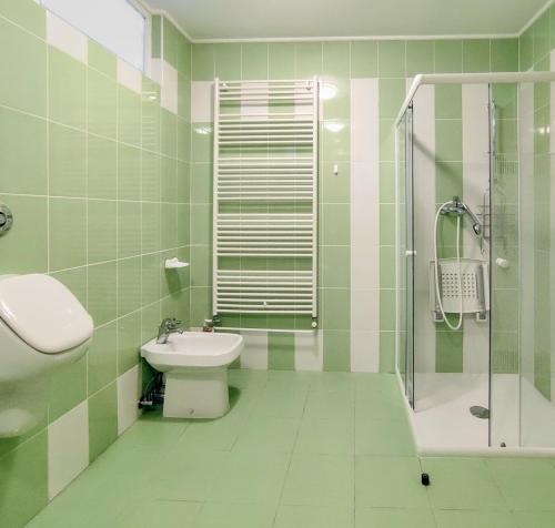 baño verde y blanco con lavabo y ducha en Harmony House Velenje, en Velenje