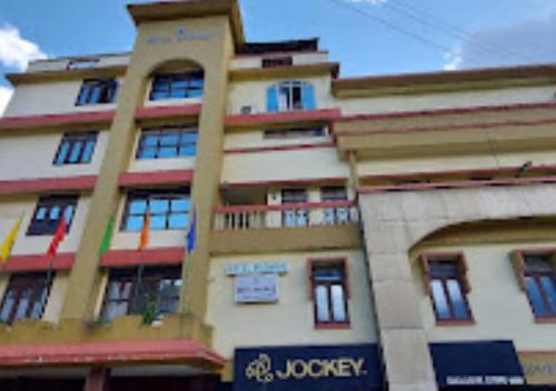 a tall building with a sign in front of it at Hotel Moomsie Itanagar Arunachal Pradesh in Itānagar