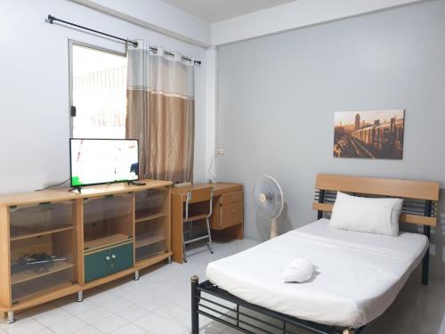 a bedroom with a bed and a desk and a television at 7/7 House, Classic House for family in Hat Yai