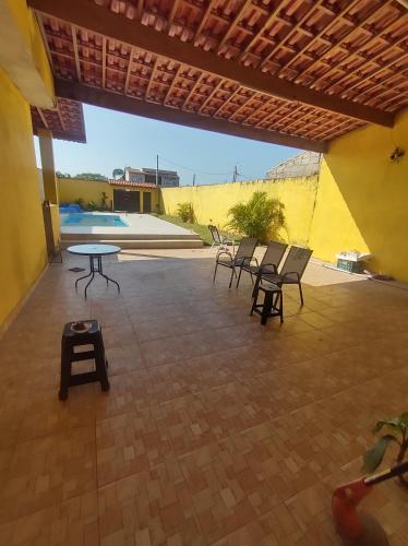 patio con sedie, tavolo e piscina di Morada de Angatu a Itanhaém