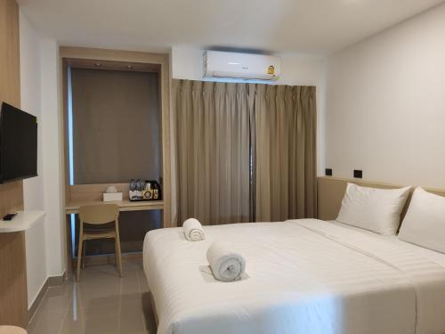 um quarto de hotel com uma cama com toalhas em SNOW HOUSE Buriram em Buri Ram