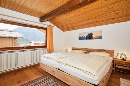 a bedroom with a bed and a large window at Alpen-Chalet Benzeck in Reit im Winkl