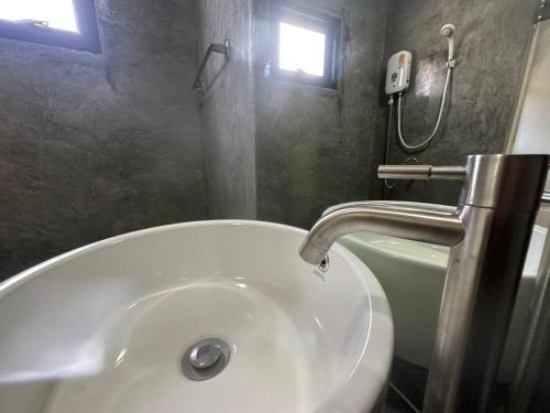 een badkamer met een witte wastafel en een douche bij The Beatles Lagoon in Ban Na Bon