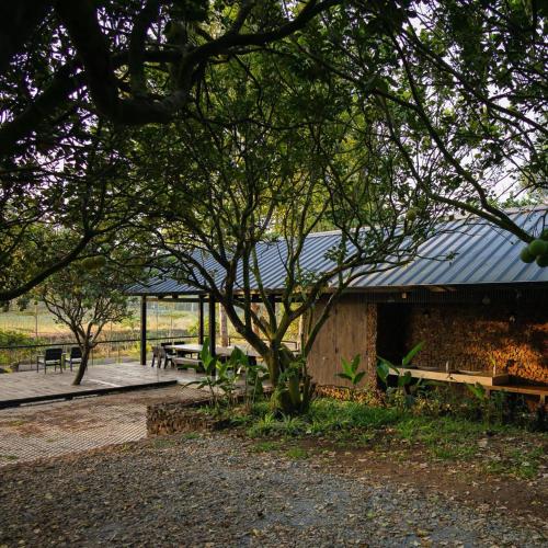 a building with picnic tables and a tree at Suối Camp in Ba Ria