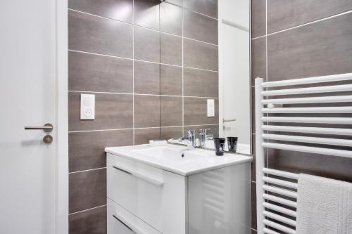 une salle de bain blanche avec un lavabo et une douche dans l'établissement Escapade sur l'île de Nantes, à Nantes