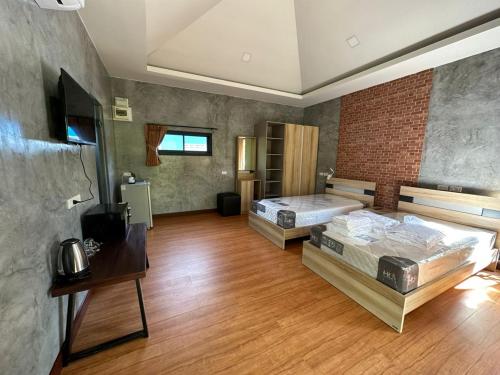 a large room with two beds and a television at The Beatles Lagoon in Ban Na Bon