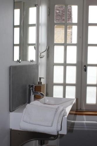une salle de bain avec un lavabo et un miroir dans l'établissement Appartement -Le Clos- Cellier de l'abbaye, à Vézelay