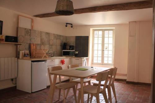uma cozinha com mesa e cadeiras num quarto em Appartement -Le Clos- Cellier de l'abbaye em Vézelay