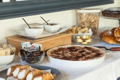 a table with various pastries and breads on it at Giardino Sul Duomo in Ragusa