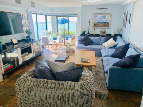 a living room with two couches and a table at 185 on BEACH Boutique Suites in Gordonʼs Bay