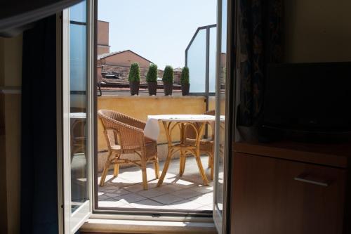 a balcony with a table and chairs and a television at Hotel Windrose in Rome