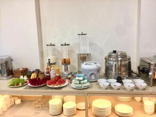a shelf with plates and cups and food on it at HANA Stay in Hanoi