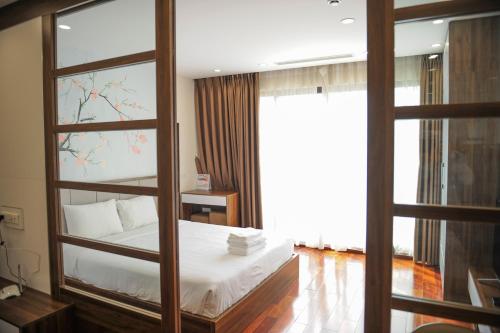 a bedroom with a bed and a large window at HANA Stay in Hanoi