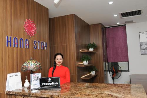 a woman standing at a counter with a laptop at HANA Stay in Hanoi