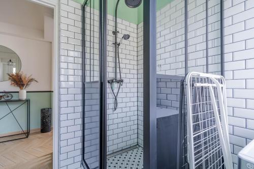 a shower in a bathroom with white tiles at Superbe appart chic, hyper centre, vue château, Parking inclus in Caen