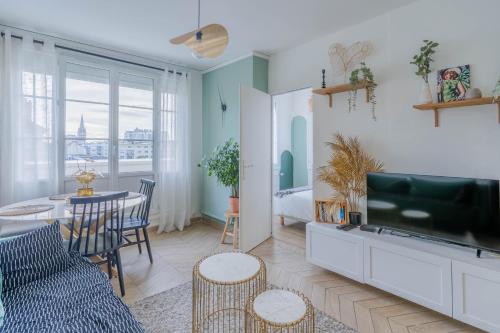a living room with a couch and a tv and a table at Superbe appart chic, hyper centre, vue château, Parking inclus in Caen