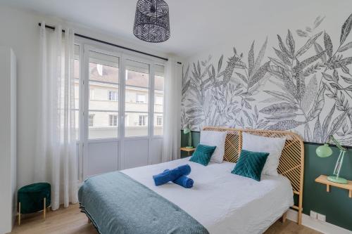 - une chambre avec un lit doté d'oreillers bleus dans l'établissement Superbe appart chic, hyper centre, vue château, Parking inclus, à Caen