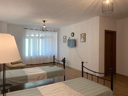 sypialnia z 2 łóżkami i oknem w obiekcie Fragment w mieście Polenitsa
