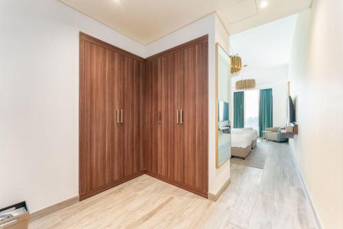 Fanciable 2BR Apartment & 1 Maids room in Avani Tower في دبي: غرفة مع خزانة خشبية كبيرة في غرفة النوم
