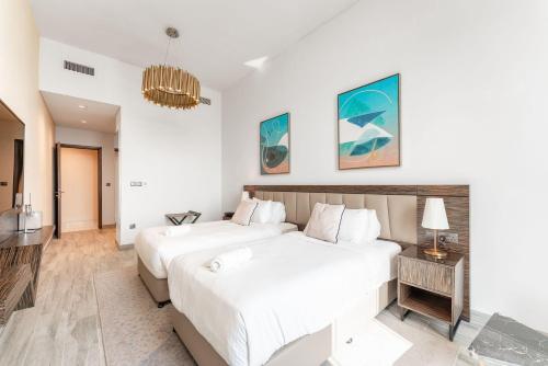 Un dormitorio blanco con una cama grande y una mesa en Fanciable 2BR Apartment & 1 Maids room in Avani Tower, en Dubái